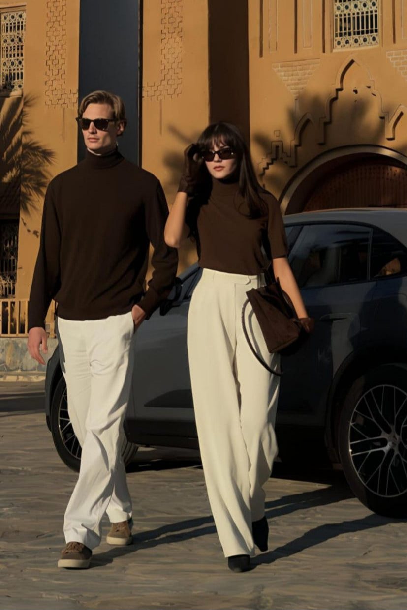Two people walking in front of a building with decorative architecture.